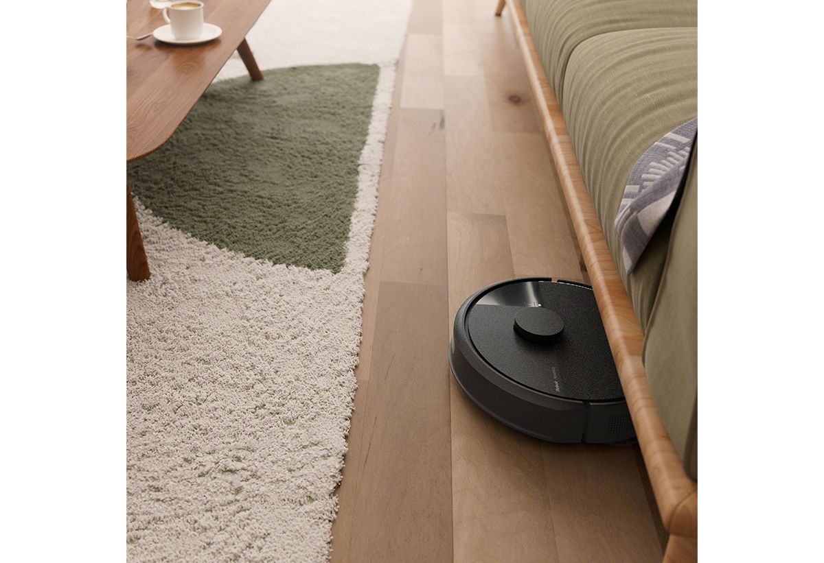 Παρουσιάζεται η σκούπα να καθαρίζει το πάτωμα ενός σαλονιού με χαλιά.